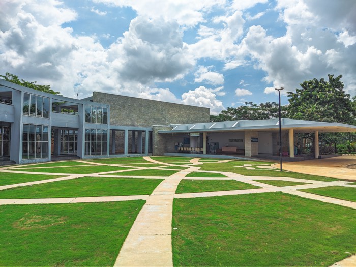 The ICTS campus courtyard, geometric paths across grass under piled monsoon clouds